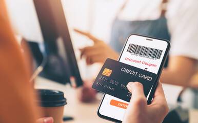 Hand holding credit card payment and using smartphone with scan barcode for discount code coupon, shopping online, Digital wallet concept.