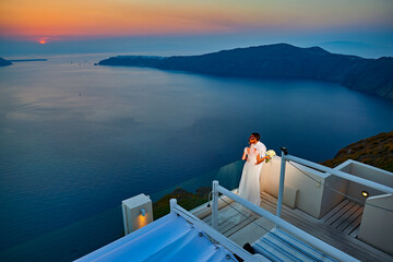 Wall Mural - Beautiful young couple bride and groom posing on Santorini island, Greece