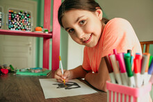 Smiling Girl Coloring Cat Picture On Paper At Home