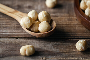 Wall Mural - Peeled hazelnuts in a wooden spoon, close-up.