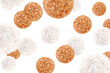 Levitation of round candies in coconut flakes and chopped nuts isolated on transparent background.