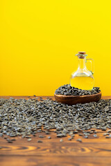 Wall Mural - oil and sunflower seeds on  wooden table on  yellow background