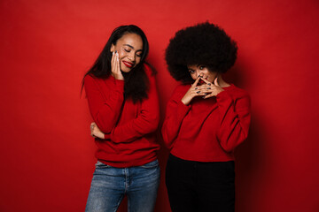 Wall Mural - Two young african american women smiling and posing at camera