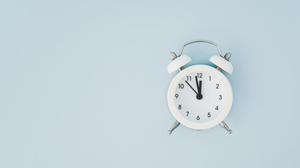 Wall Mural - top view of white analog alarm clock on grunge blue background including copy space