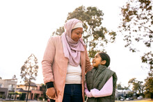 Middle Aged Woman Wearing Pink Hijab And A Girl Wearing Green Coat Looking At Each Other