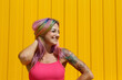 © VISTA by Westend61 - Happy woman with colorful dyed hair in front of yellow wall