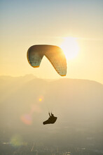 Paraglider Silhouette Flying At Sunset