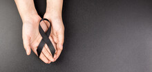 Hand Hold Black Ribbon On Background.
Bereavement And Mourning Is The Grieving Process Concept.