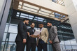 © xartproduction - Business people outdoor meeting. Men in jackets discuss working moments together by brainstorming. Teamwork and partnership in business processes