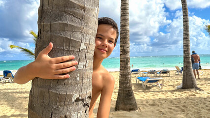 Wall Mural - Young boy is enjoying on the beautiful tropical beach at summer.