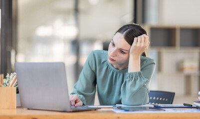 Portrait of tired young business Canada american woman work with documents tax laptop computer in office. Sad, unhappy, Worried, Depression, or employee life stress concept	