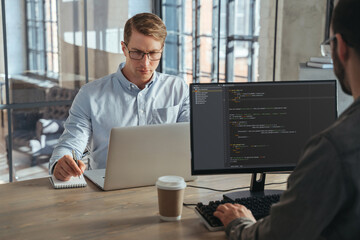 Wall Mural - two it specialists co-working at office, working on new product, analyzing data, programming new sof