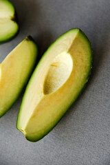 Wall Mural - Green avocado fruit cut into slices on a white background. Avocado on a white plate. Avocado slices and halves