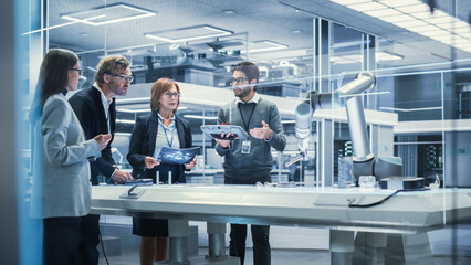 Leinwandbilder - Professional Multicultural Team of Female and Male Engineers Using Industrial Programmable Robotic Arm in a Factory Development Workshop. Tech Facility with Machines, Computers and Research Equipment.