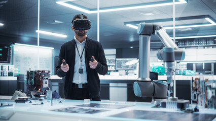 Fototapete - Portrait of a Young Specialist Using a Virtual Reality Headset with Controllers to Operate an Experimental Robotic Arm Machine. High Tech Industrial Laboratory Facility.