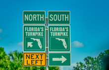 Florida's Turnpike Road Signage Against Palms And Blue Sky