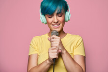 Cheerful Woman In Headphones Singing Into Microphone