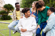 © Xavier Lorenzo - Happy multiethnic group of young friends having fun together outdoor. Friendship and community concept with multiracial teenager people hanging out in city street