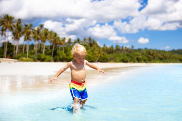 Wall Mural - Kids play on tropical beach. Sand and water toy.