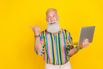 Canvas Print - Photo of positive handsome man hold netbook look direct finger empty space isolated on yellow color background