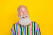 Photo of charming dreamy man wear colorful striped shirt looking empty space isolated yellow color background