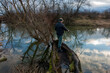 © mikhailgrytsiv - a fisherman on the shore of a pond pulls a spinning fish on a cloudy day