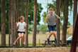 © bilanol - Two young teenage children, girl and boy playing on swings together outdoors on bright sunny vacations day