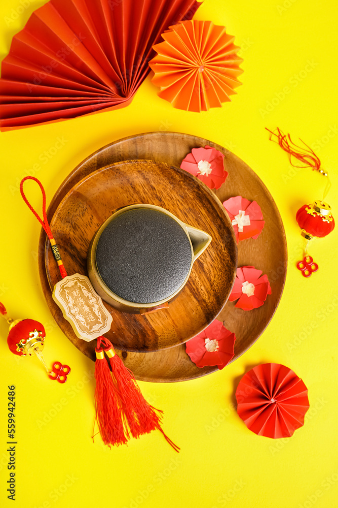 Plates with teapot and Chinese symbols on yellow background