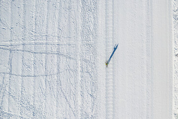 Wall Mural - Active man cross-country skiing on snow sunny day, drone top view. Concept winter sport for health habit