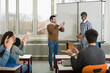 © Cavan Images - University student finishing classroom presentation, students and teacher clapping School, Bavaria, Germany