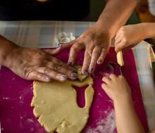 Hands Of Adult Woman And A Child Cutting Out Cookies