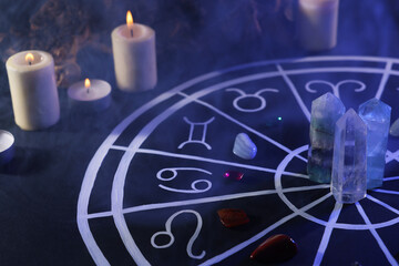 natural stones for zodiac signs, drawn astrology chart and burning candles on black table. color ton