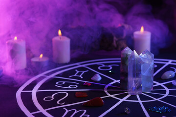natural stones for zodiac signs, drawn astrology chart and burning candles on black table. color ton