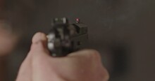 Overshoulder Of 9mm Pistol Being Fired And A Casing Being Ejected In Slow Motion