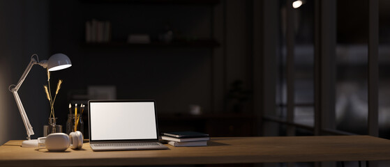 Wall Mural - Modern office workspace at night, Laptop mockup, light from table lamp and copy space on tabletop