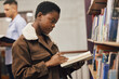 © S Fanti/peopleimages.com - Education, book or black woman reading in library at university, college or school learning or studying. Research, scholarship or gen z African girl focused on knowledge growth or student development