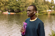 © Raisa Kanareva - Young handsome African American sport man tired and thirsty after running workout holding bottle drinking water