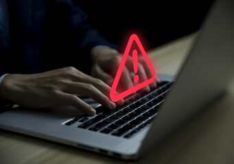 Wall Mural - businessman using laptop showing warning triangle and exclamation sign icon warning of dangerous pro