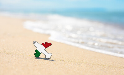 Vacation on the coast of Italy. Airplane in the colors of the flag of Italy on the seashore