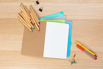 Wall Mural - Notebook mockup with school stationery on a wooden table. back to school concept. Blank notepad with copy space. list of goals and plans for new year 2023