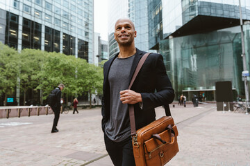 young business man going to work in the morning passing by the financial street area of the city .Representation of a successful sales person reaching the top of the career.