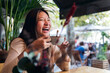 © Raul Mellado - young asian woman laughing while drinking coffee during her date at a coffee shop, concept of relaxation and leisure