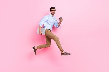 Poster - Full length photo of young running air jump student guy first morning with fresh cofee before job hold computer isolated on pink color background