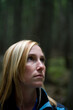 © Cavan Images - Portrait of attractive young woman hiking on boardwalk in lush green woods.
