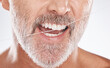 © C Davids/peopleimages.com - Floss, dental and face of senior man in studio isolated on a gray background. Cleaning, hygiene and elderly male model with product flossing teeth for oral wellness, tooth care and healthy mouth.