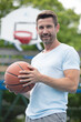 © auremar - waist up portrait of man wearing posing with basketball ball