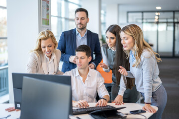 Group of business people working together on computer in office