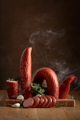Wall Mural - Smoked sausage with thyme and garlic on a wooden table.