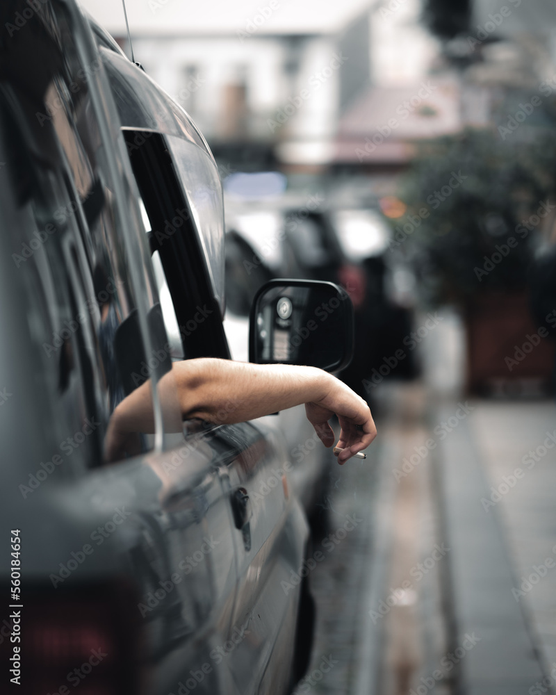 smoking cigarette out window Smoking Cigarette held out of car window Stock Photo