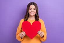 Photo Of Cheerful Friendly Girl Beaming Smile Hands Hold Paper Red Heart Isolated On Violet Color Background